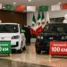 Dos coches eléctricos compactos en un showroom, uno con rótulo 50 km y otro 100 km, con colores de México